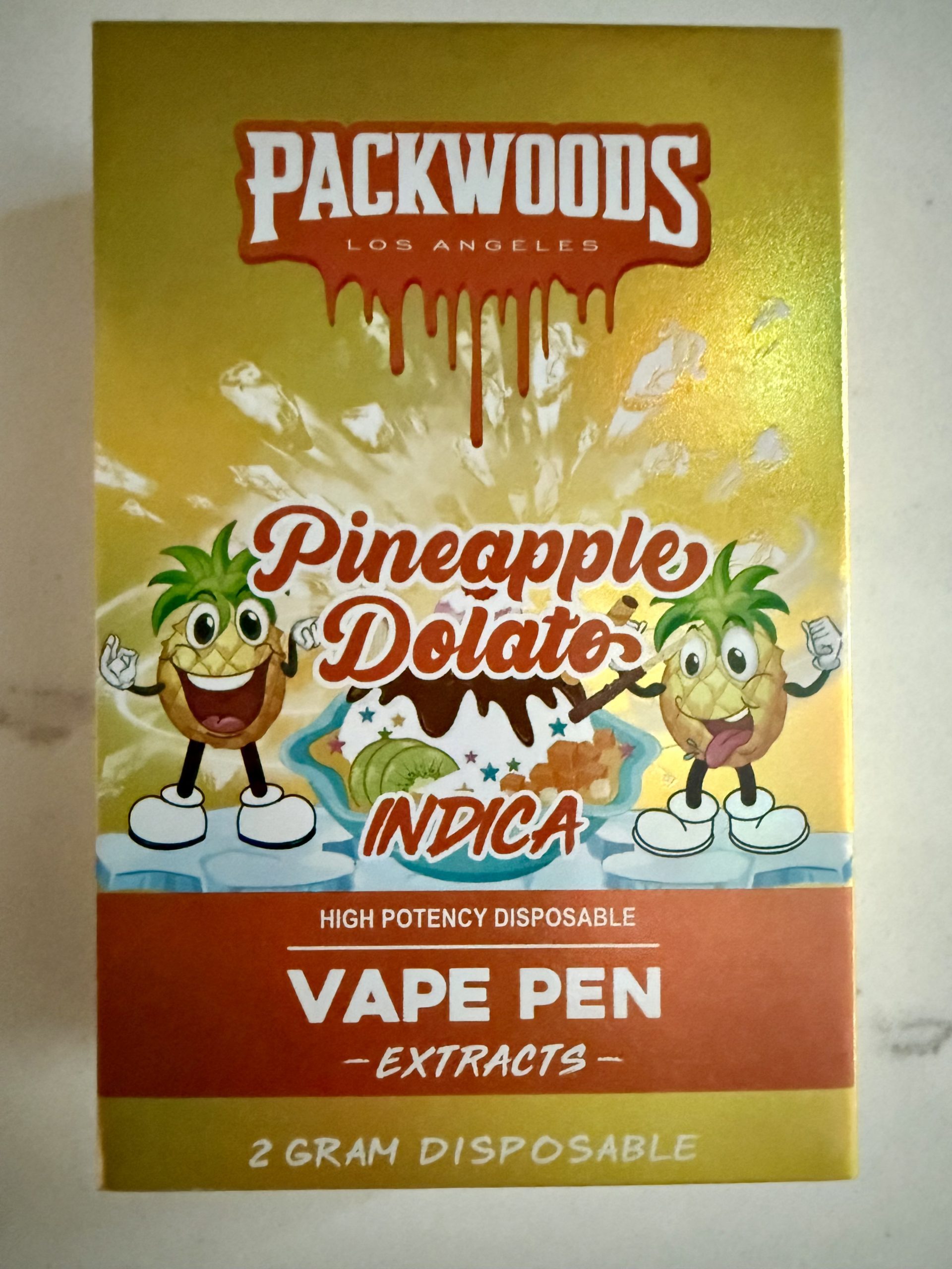 Front of Packwoods Pineapple Dolato disposable vape box with pineapple mascots and indica label