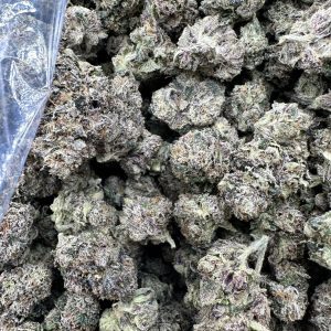 Gushers strain loud flower macro displaying heavy white trichome frost, dense calyx layering, and fire-tier bud structure